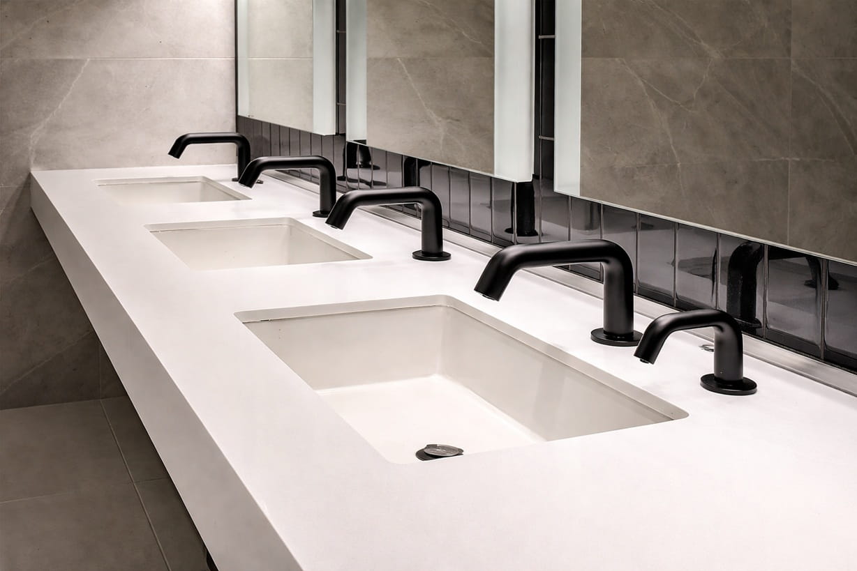 Transit hub washroom with high-capacity touchless faucet installations